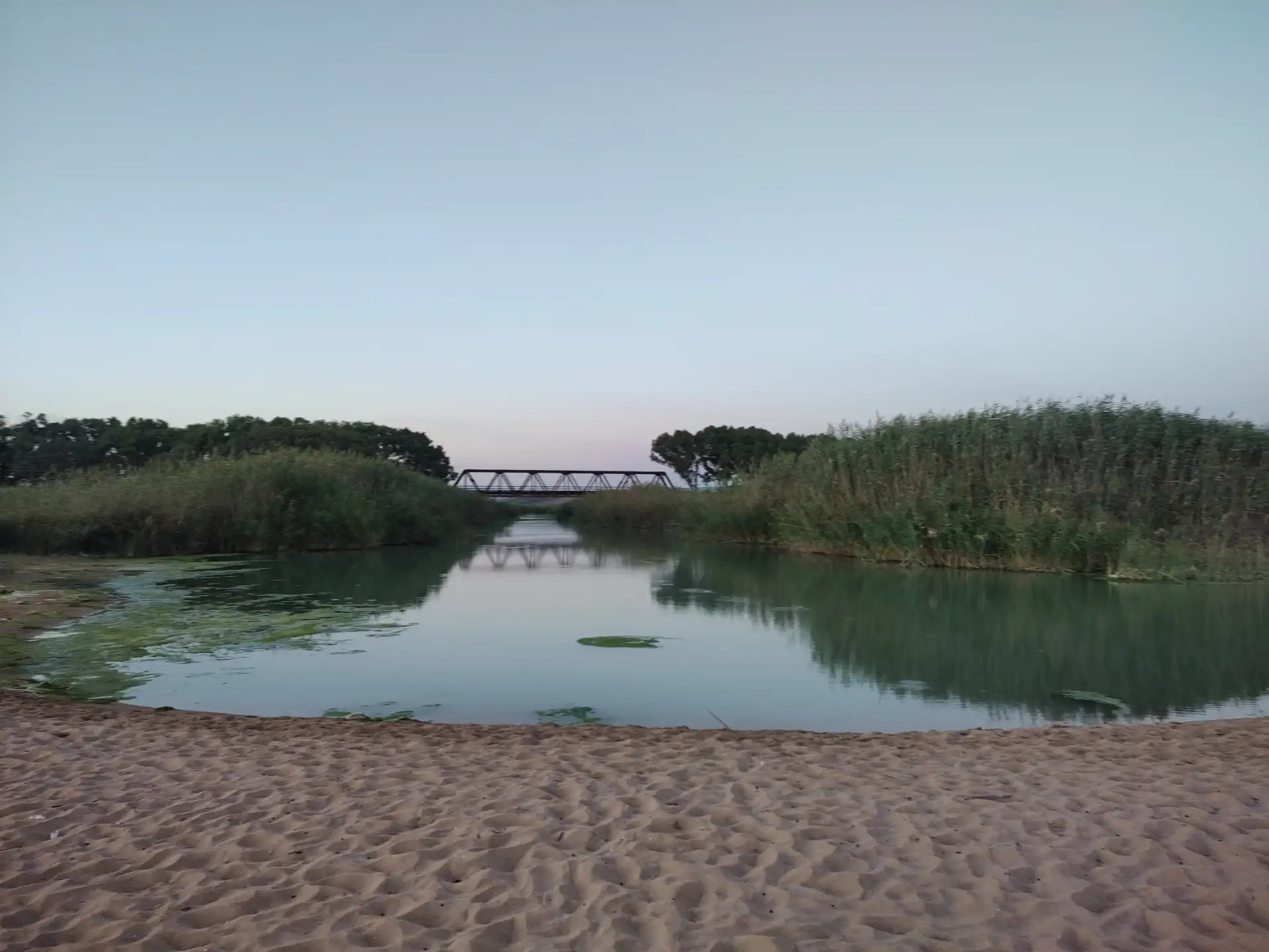 贝里切河缓缓注入地中海的壮丽交汇点，金色沙嘴与蔚蓝海水分野鲜明。