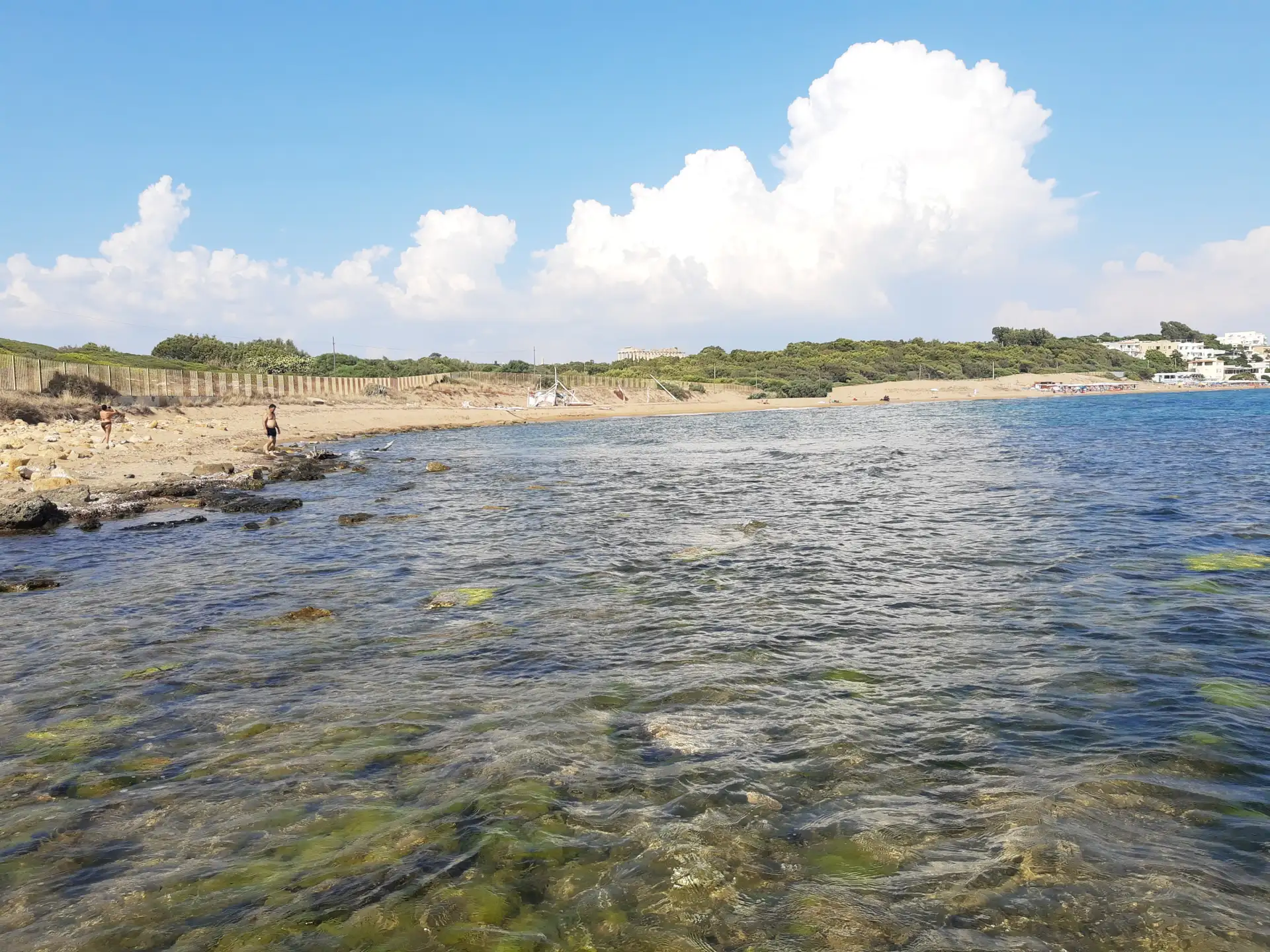 从扎巴拉海滩（Lido Zabbara）望向高耸的塞利农特古希腊卫城。金色细腻的沙滩、清澈见底的蔚蓝海浪与千年的古文明遗迹在此完美交融。走到沙滩尽头的角落，利用手机镜头拉近远处的E号神庙，就能拍出人在海中、神庙在身后的史诗级绝美大片。